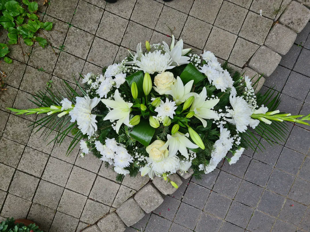 Podlhovastá ikebana s bielymi gladiolami a ľaliami