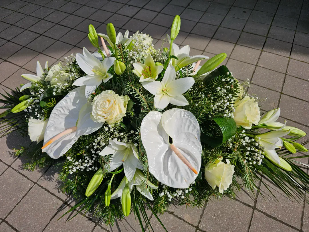 Ikebana s bielymi anthúriami, ľaliami a ružami