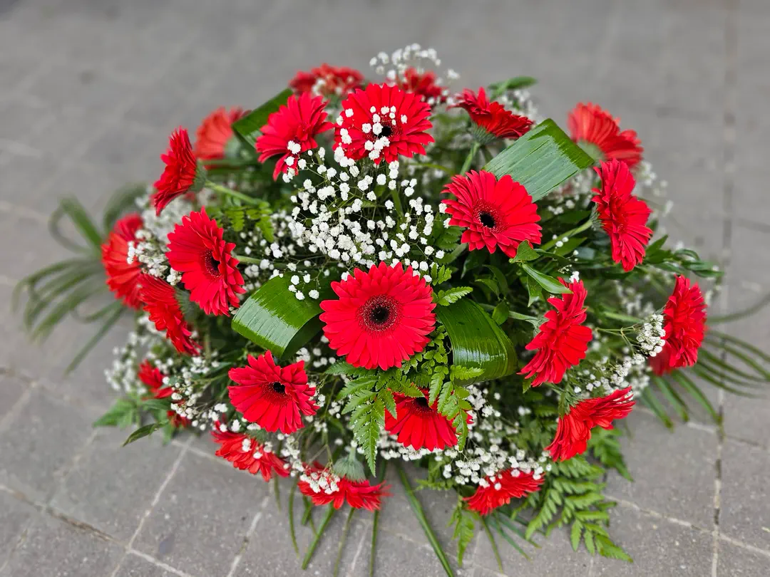Okrúhla ikebana z červených gerber a gypsomilky