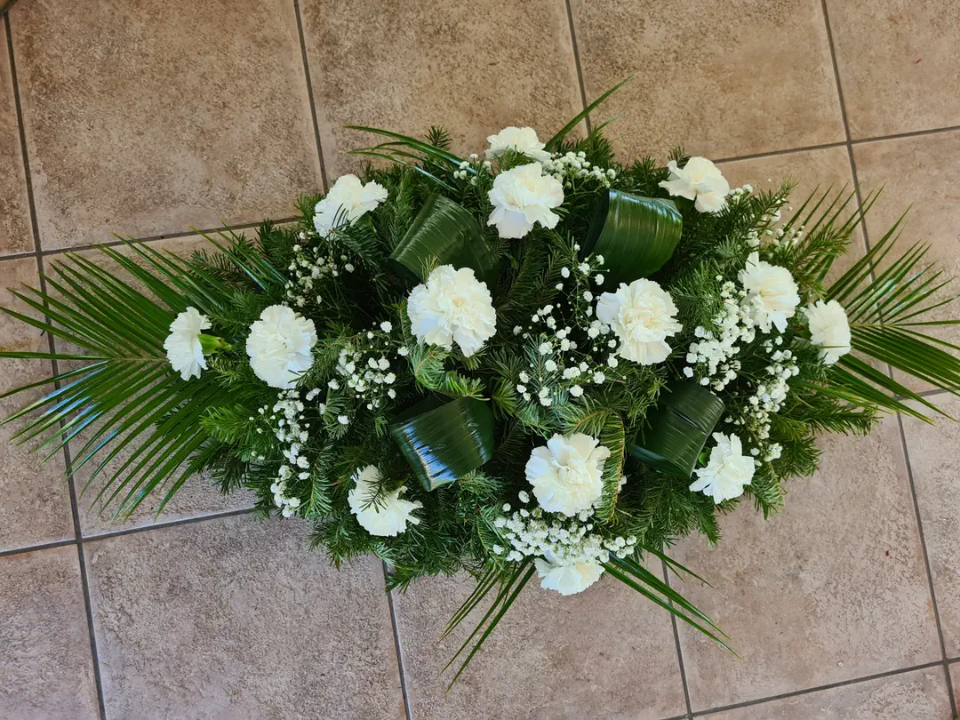 Ikebana z bielych karafiátov s palmovými listami